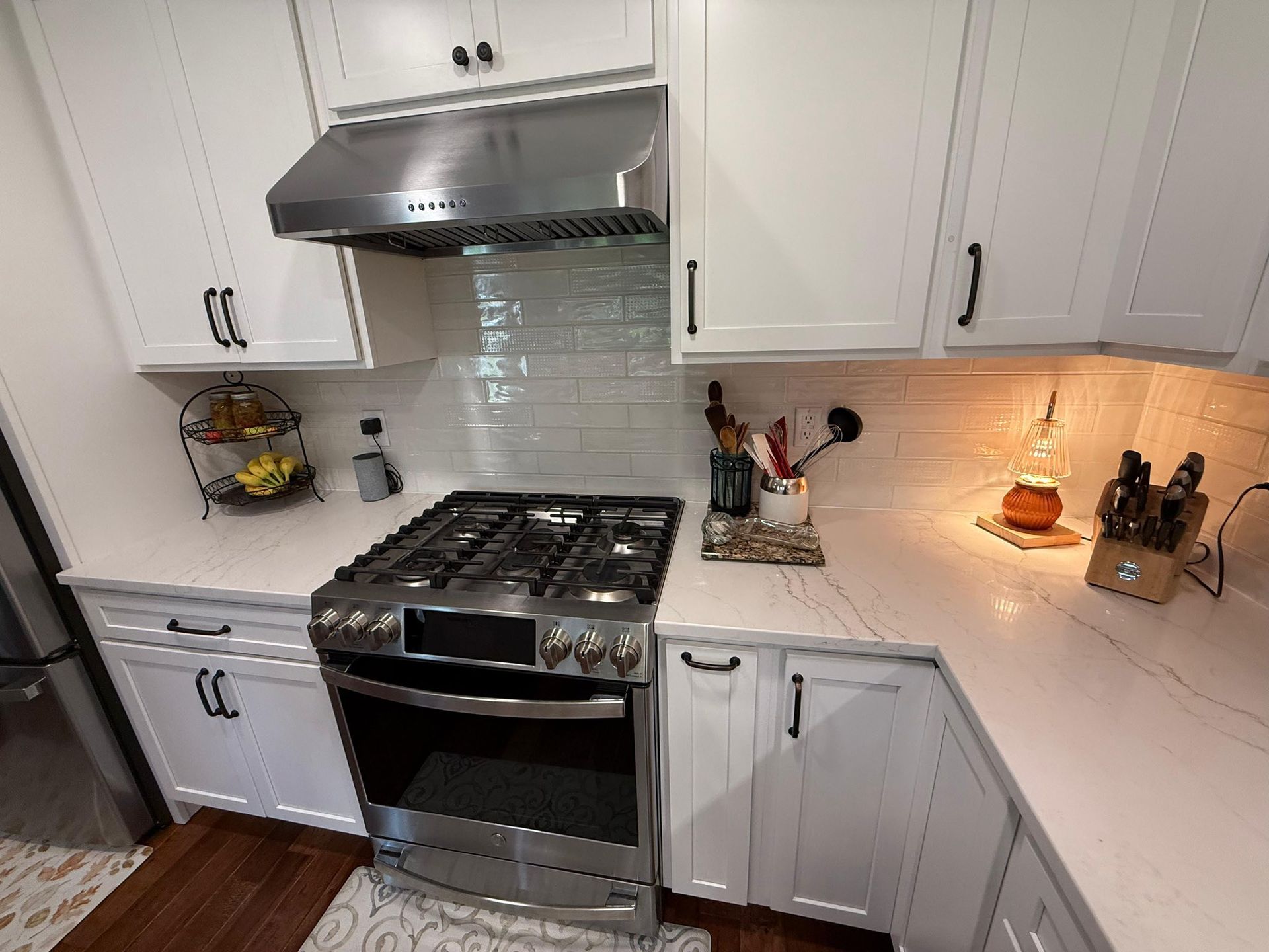 A modern kitchen with white cabinets, stainless steel appliances, and a gas range