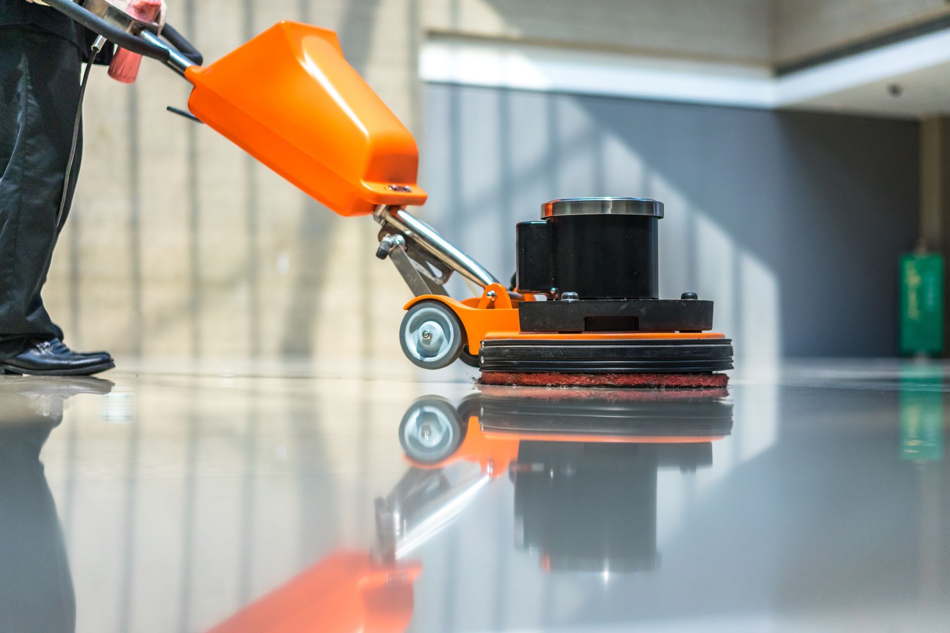 A man is using a floor scrubber for deep cleaning.