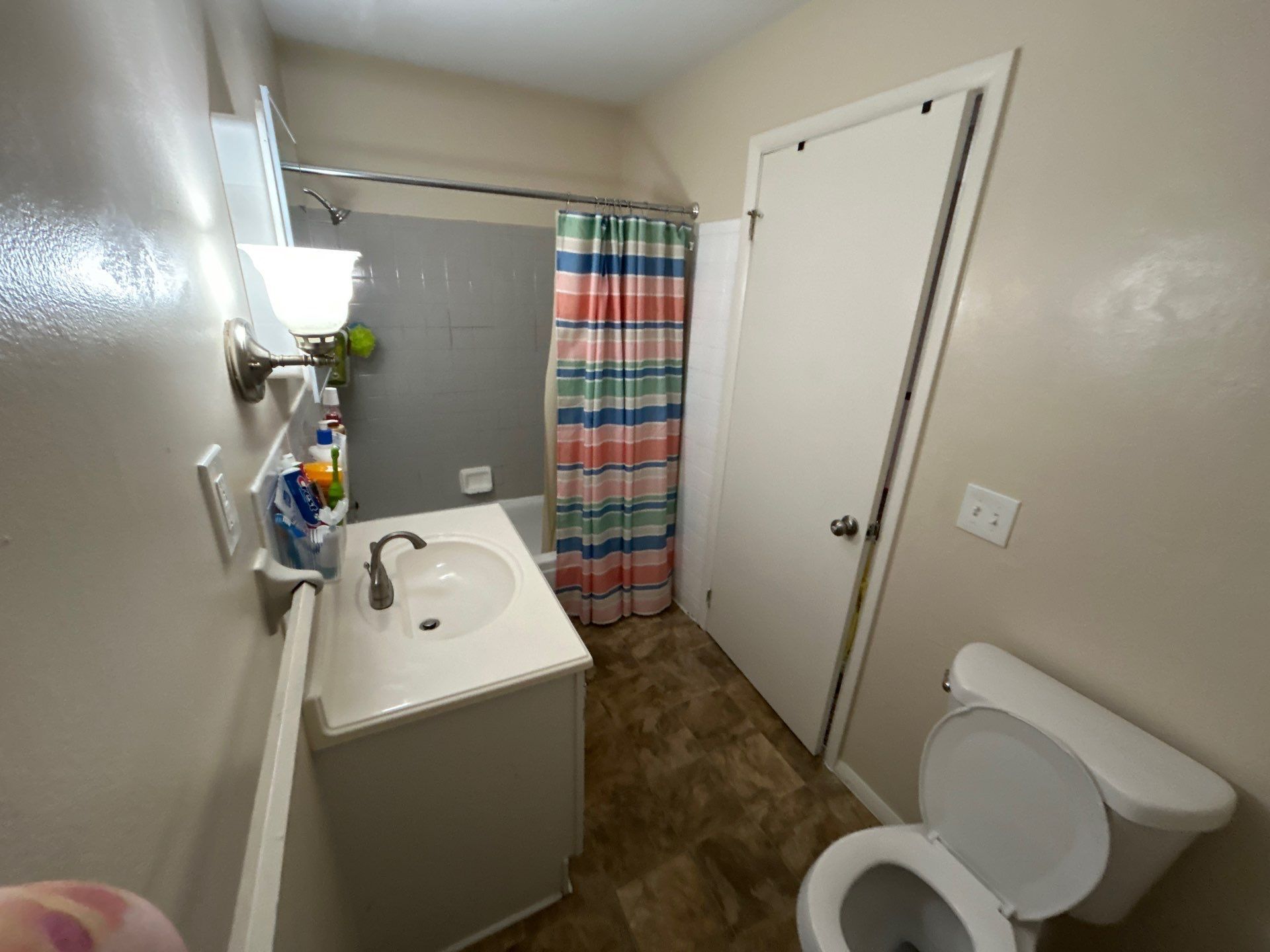 Small bathroom with toilet, sink, and shower