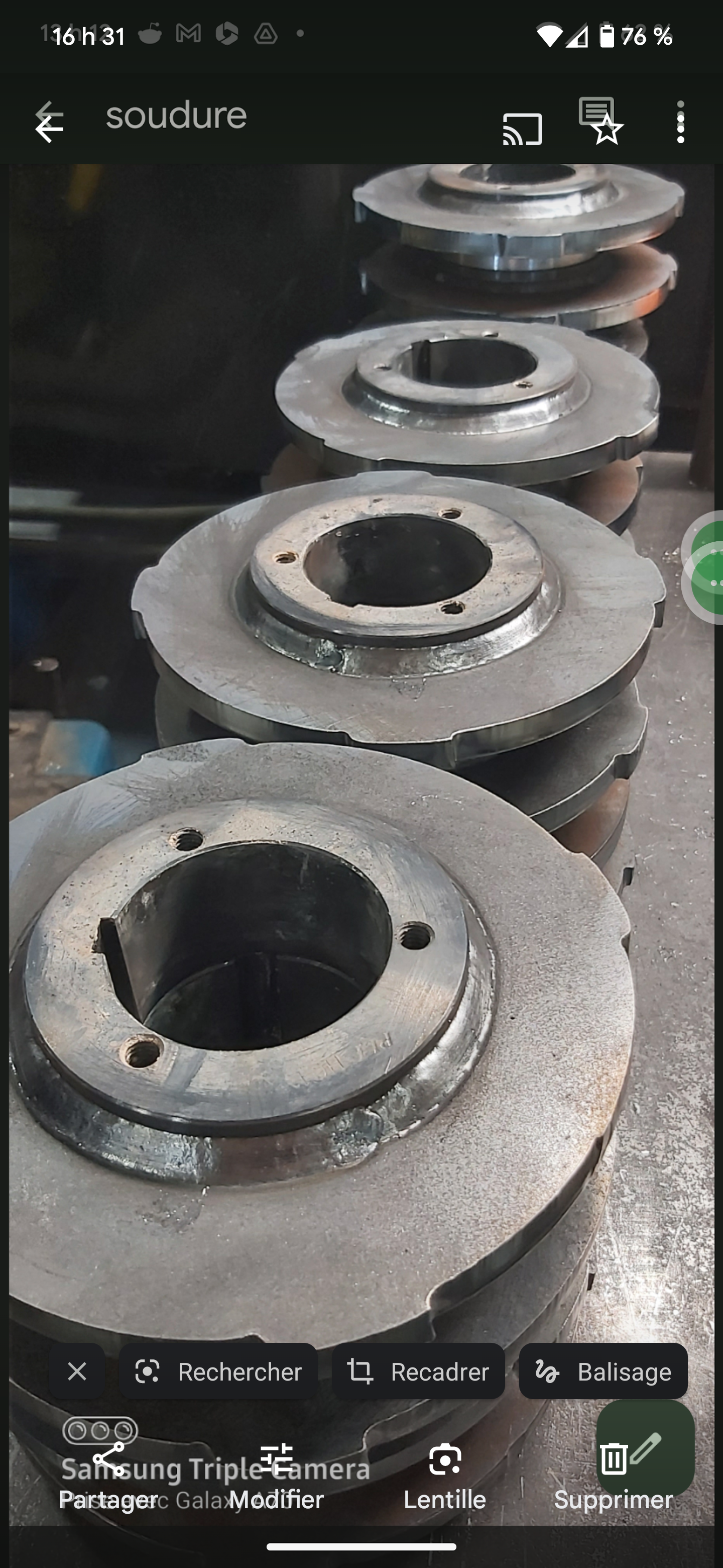 Gros plan de plusieurs composants métalliques circulaires, probablement des engrenages ou des poulies, disposés en pile. Il semble s'agir de pièces industrielles.