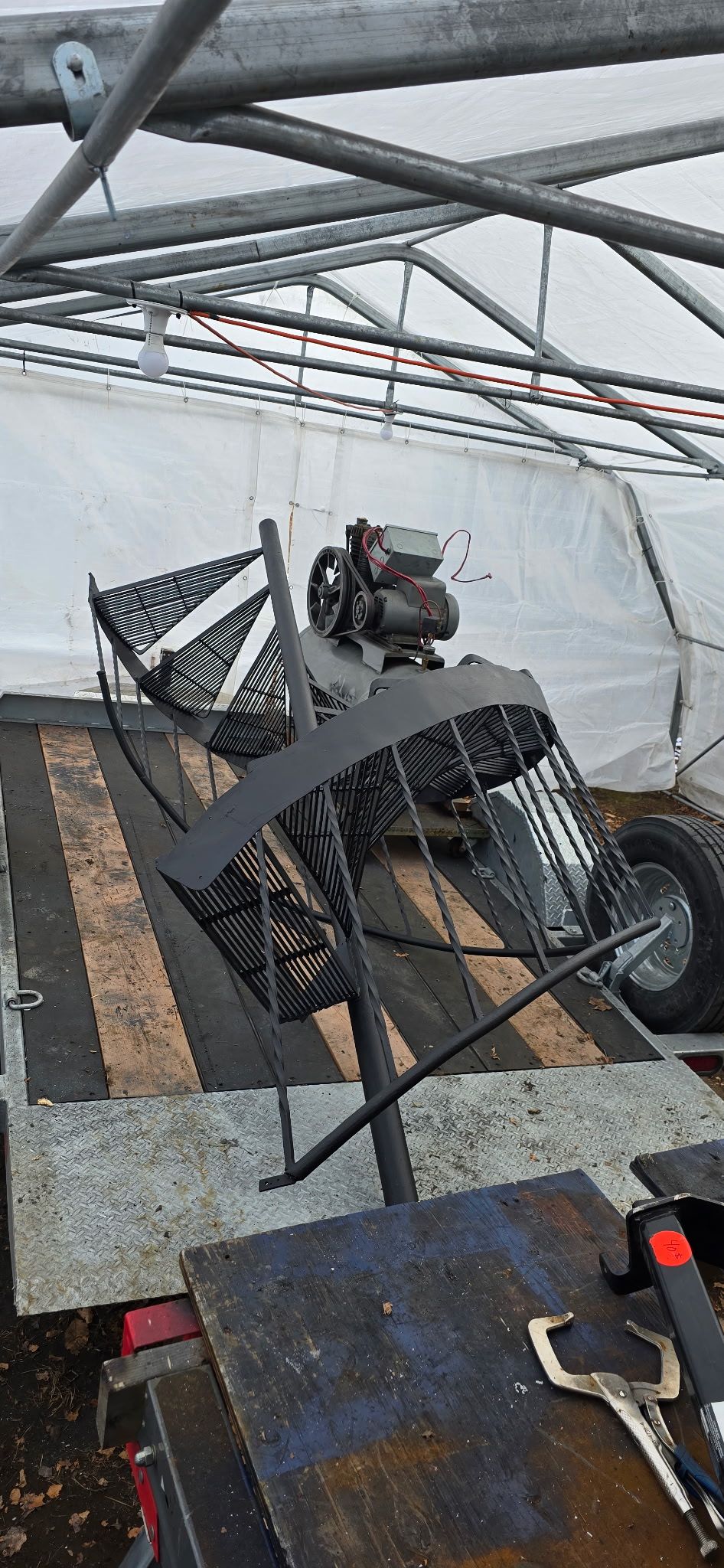 Machine en métal sur une remorque à l'intérieur d'une structure à parois blanches.