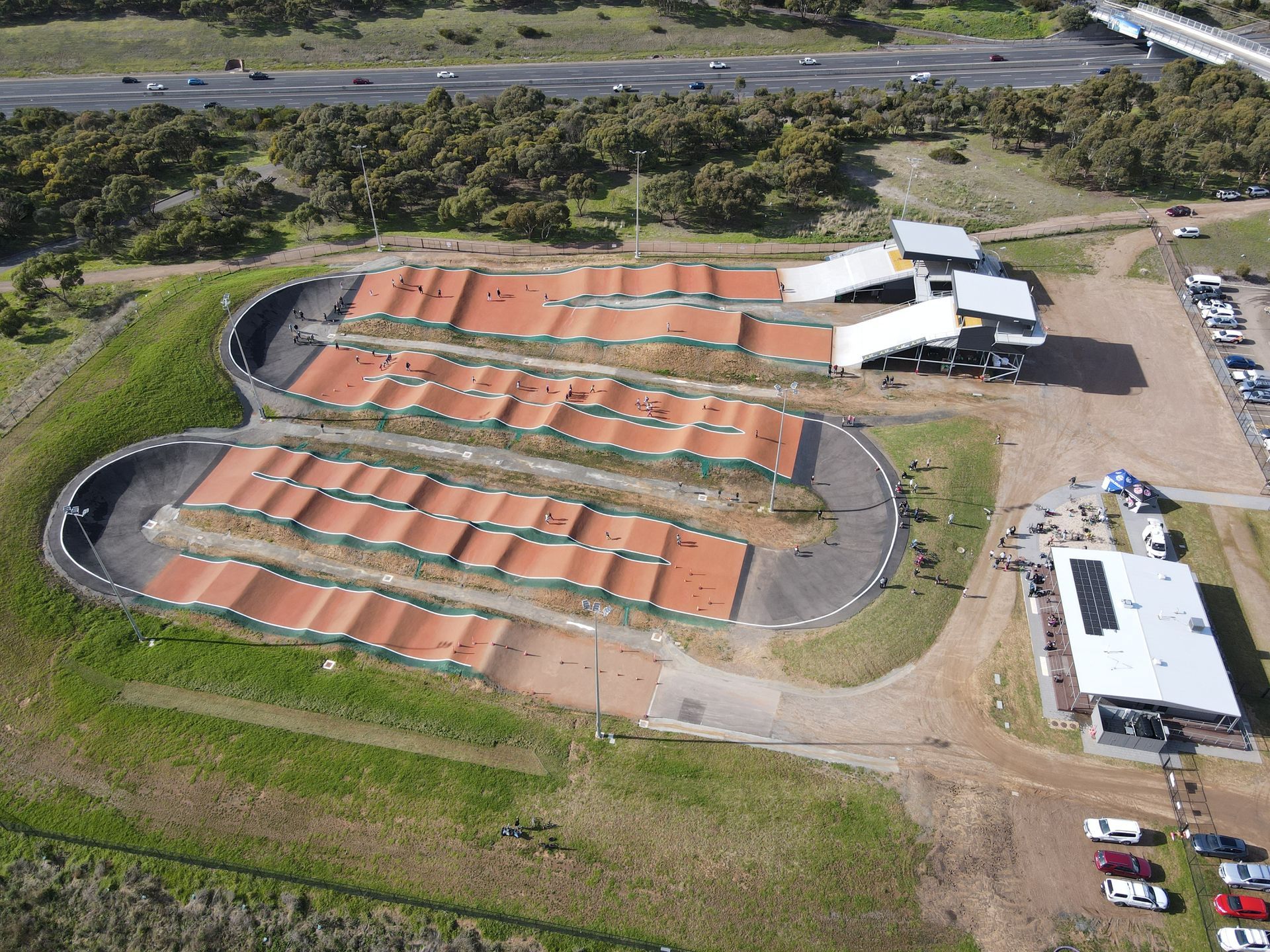 An aerial view of a bmx track with cars parked in front of it