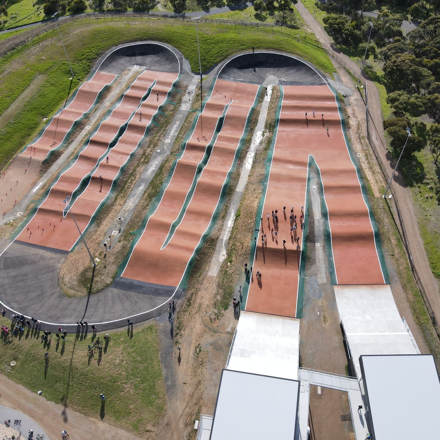 An aerial view of a bmx track with a building in the background