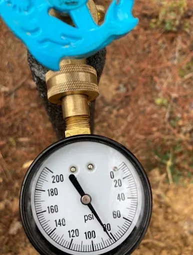 Water pressure gauge reads approximately 180 psi, connected to a brass fitting and blue faucet handle.