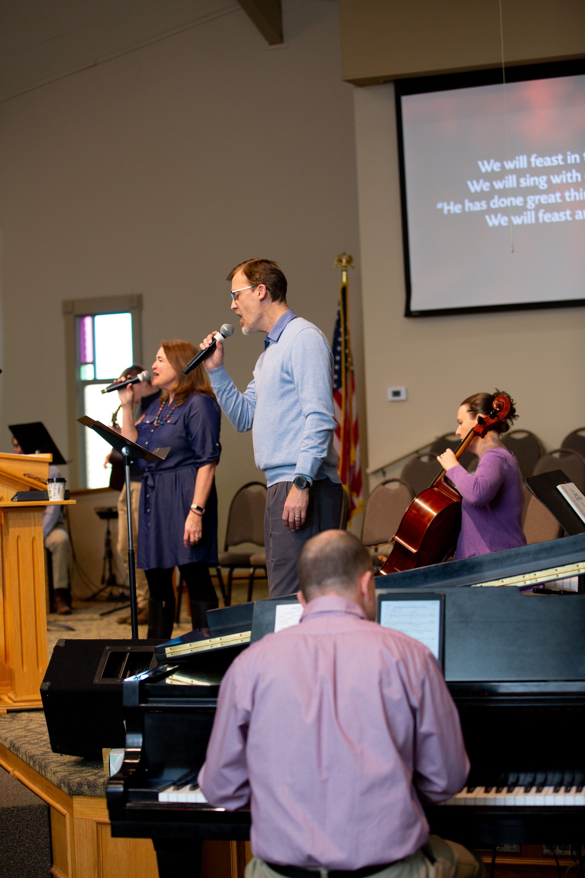 a group of people singing in front of a projector screen