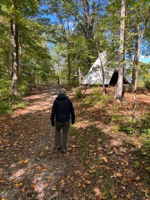 a man is walking down a path in the woods .