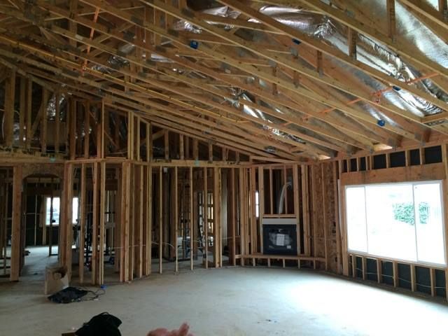 The inside of a house under construction with a fireplace and windows