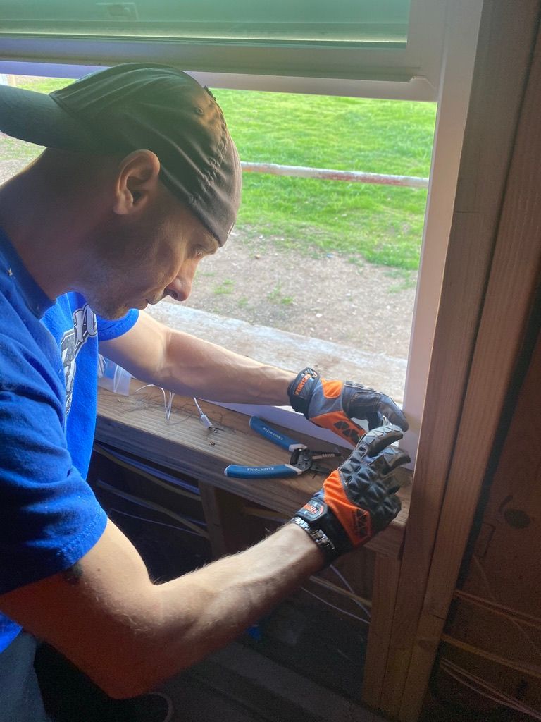 A man is working on a window with a pair of pliers.