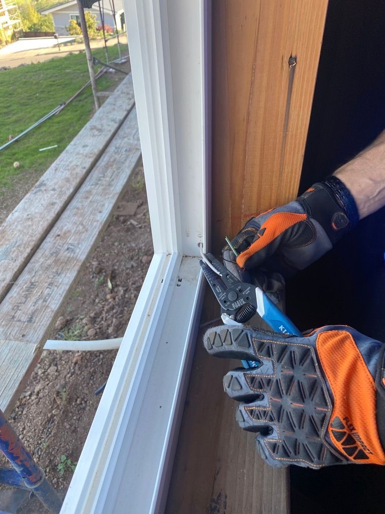 A person wearing gloves is working on a window.