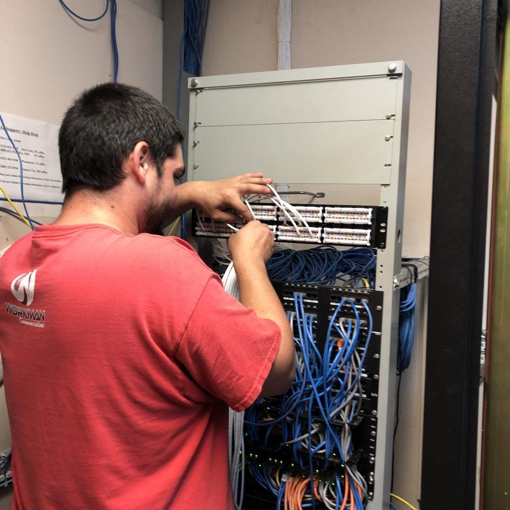 A man in a red shirt is working on a server