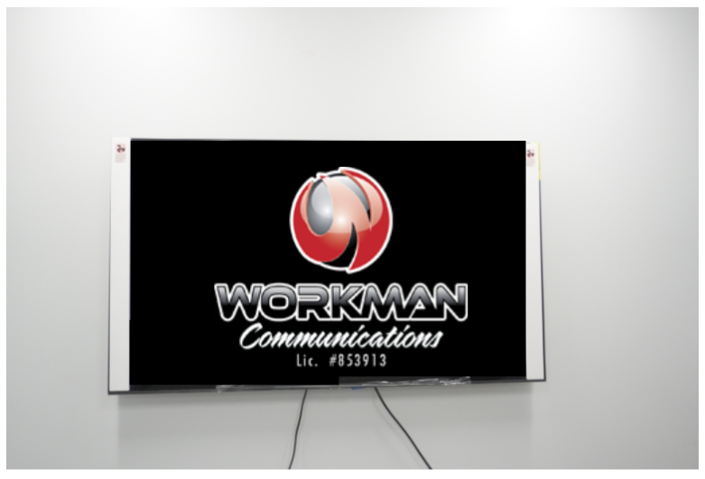 A workman communications sign is hanging on a wall