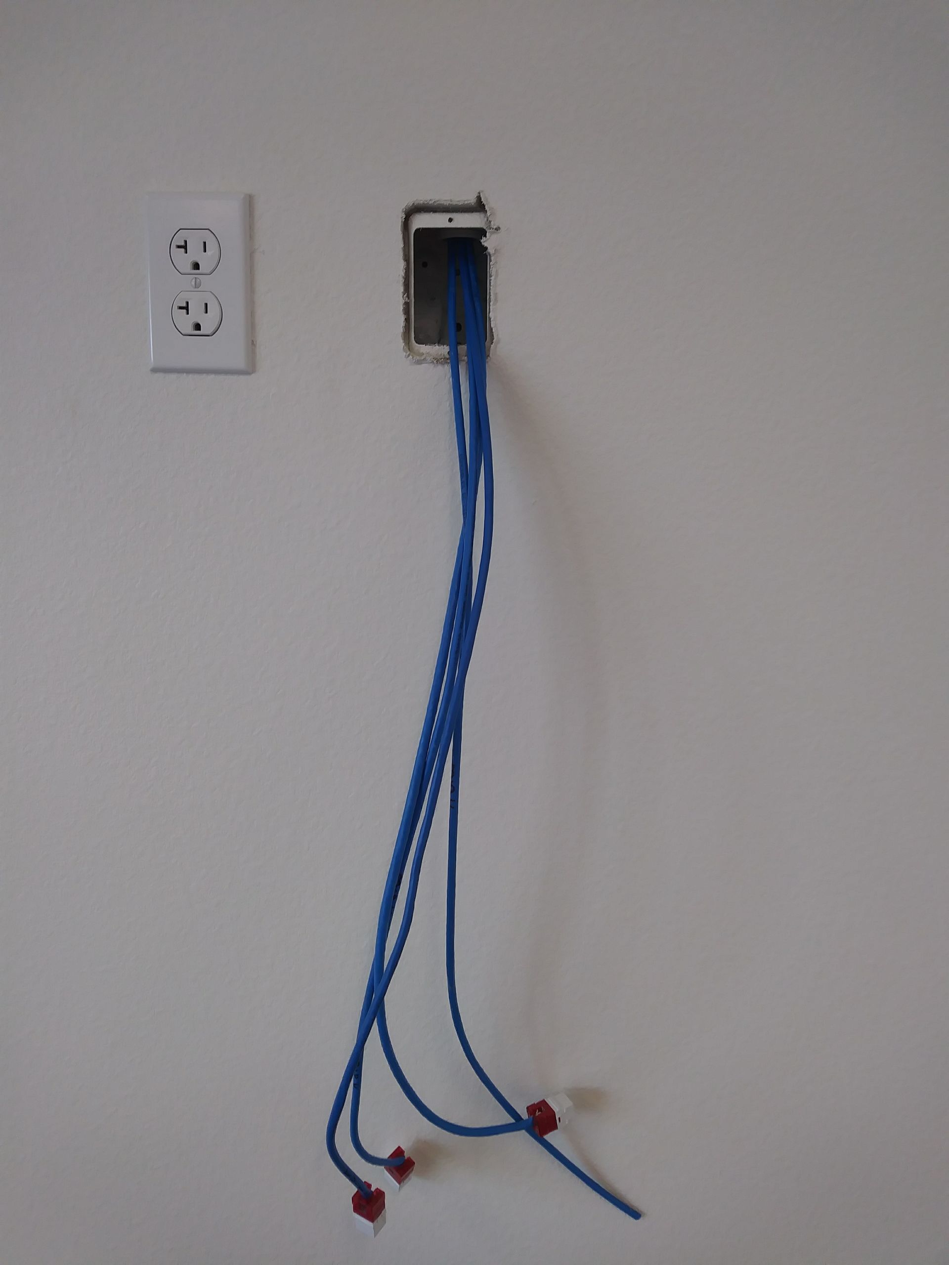 A blue cord is plugged into a wall outlet