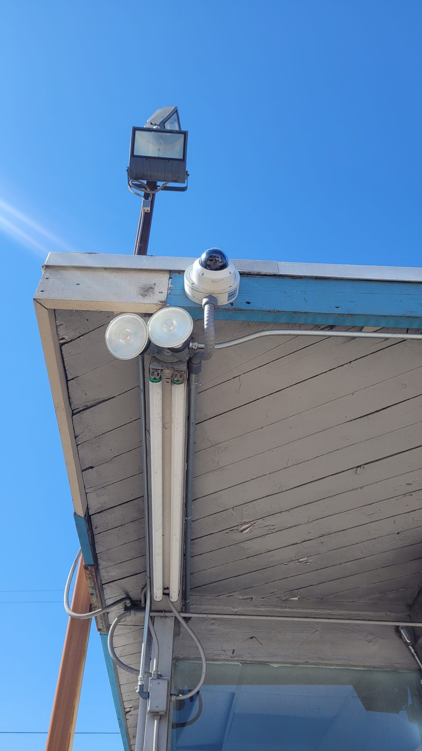 A security camera is mounted on the roof of a building.