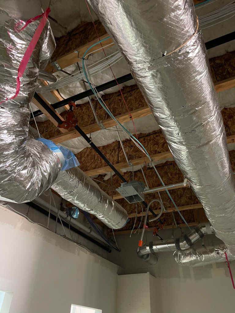 A room with a lot of pipes hanging from the ceiling.