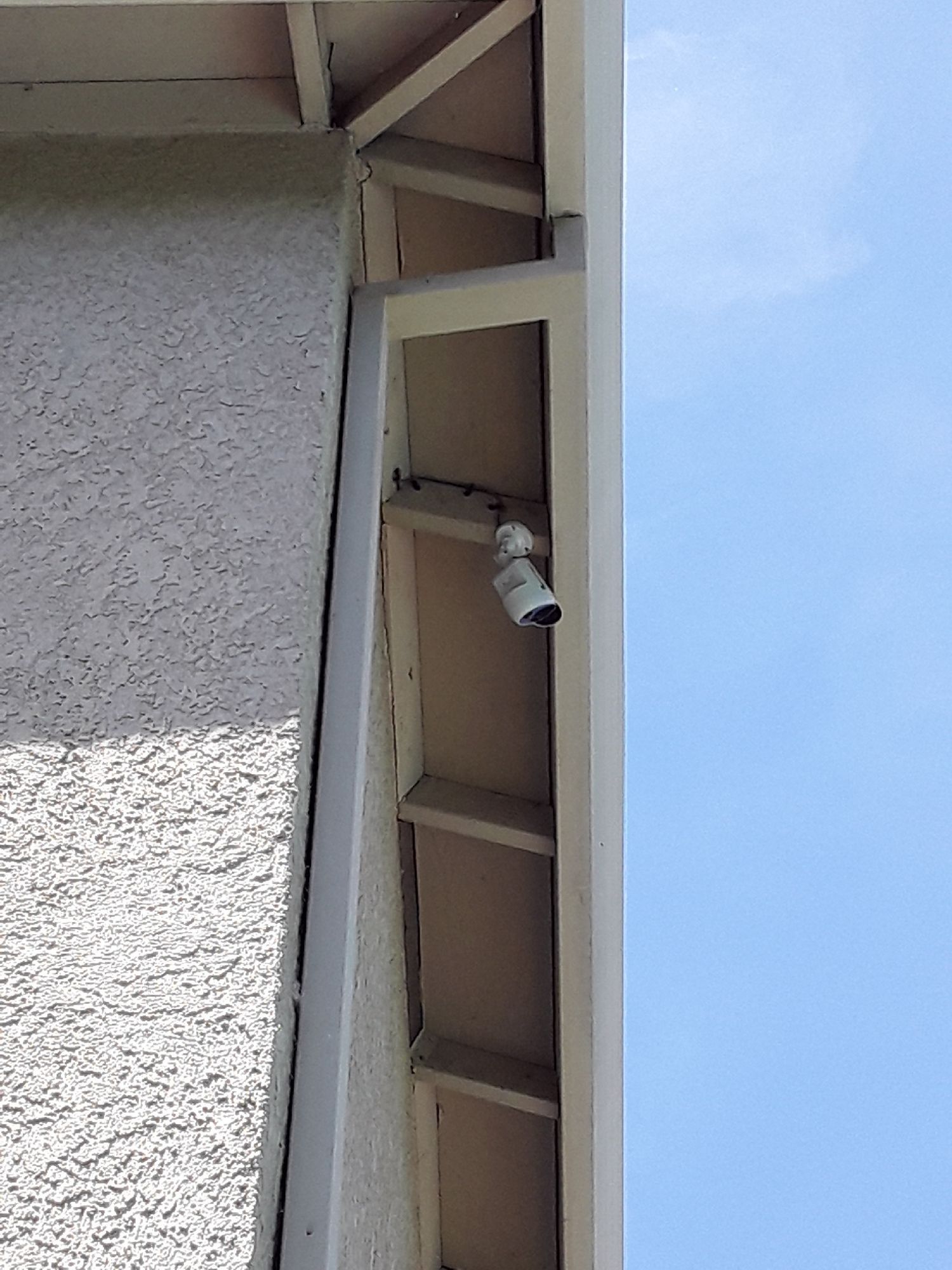 A security camera is mounted on the side of a building.