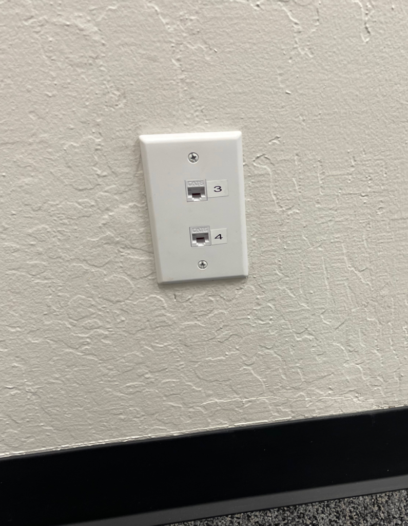 A white electrical outlet on a white wall.