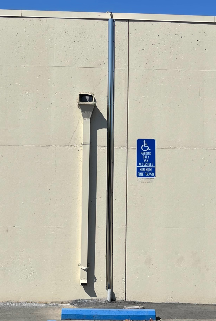 A white wall with a blue sign on it that says no parking