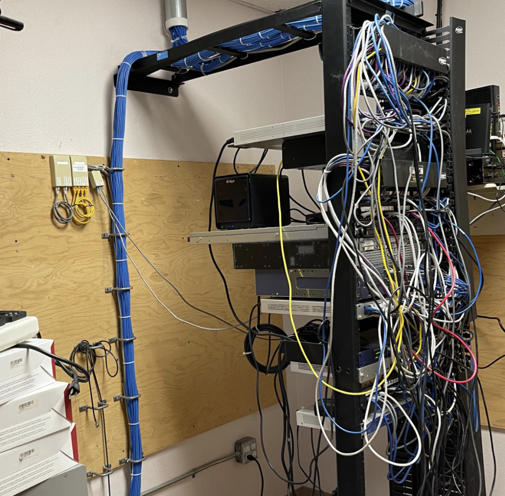 A bunch of wires are hanging from a rack in a room