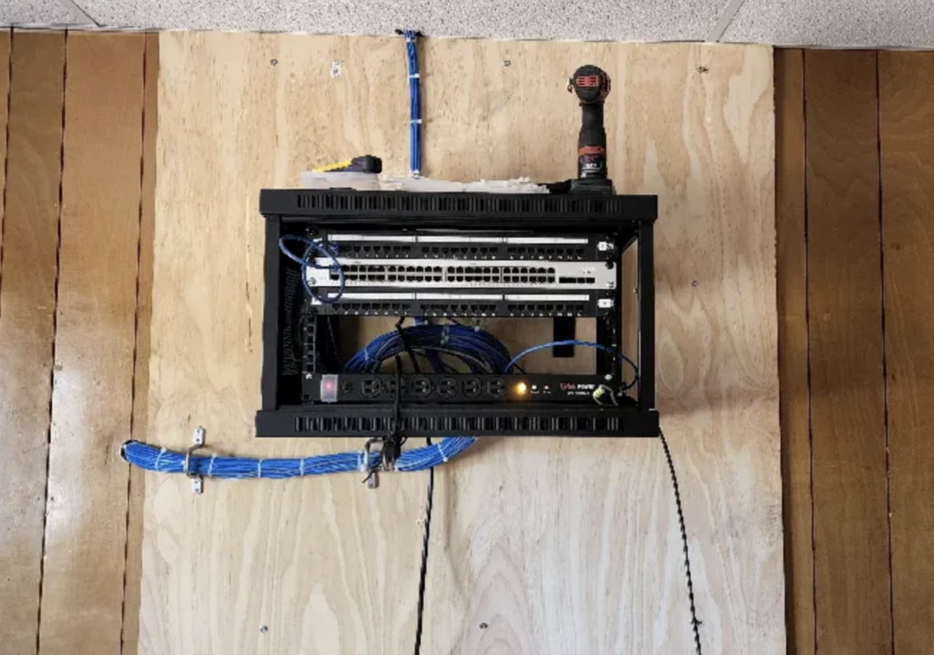 A wall mounted server with a screwdriver on top of it