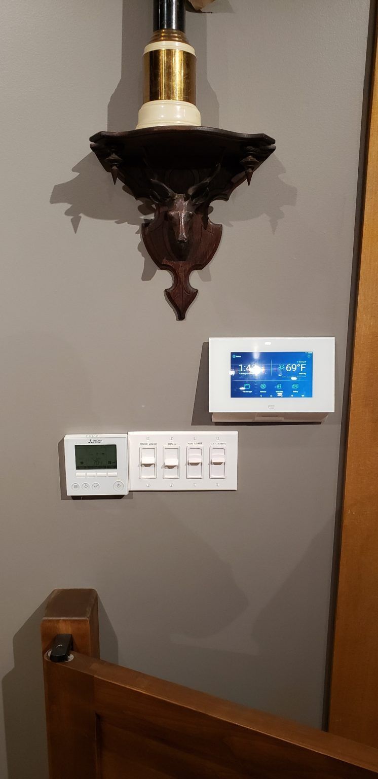 There is a thermostat on the wall next to a lamp.