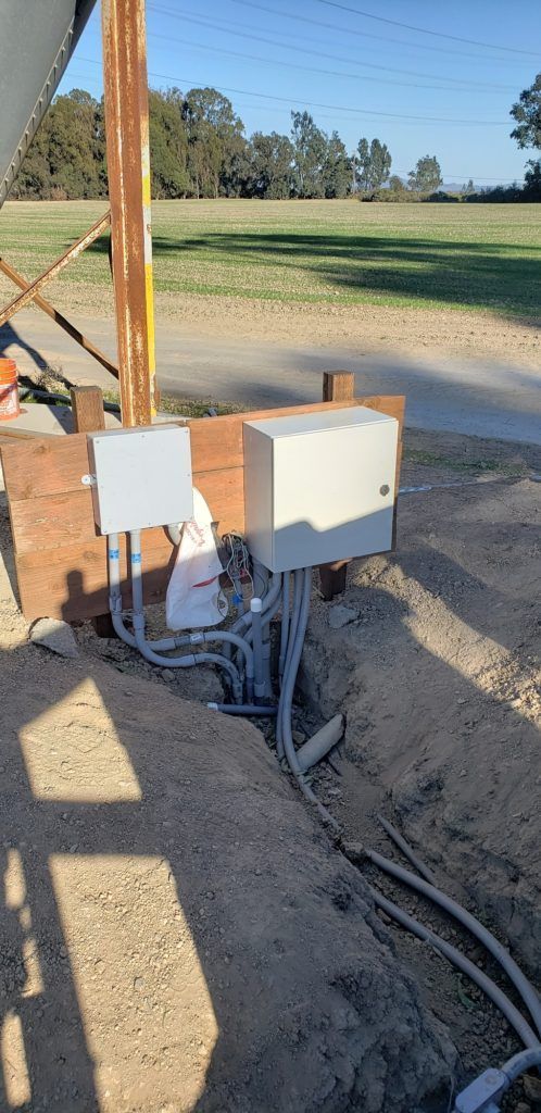 A bunch of wires are coming out of a hole in the ground.