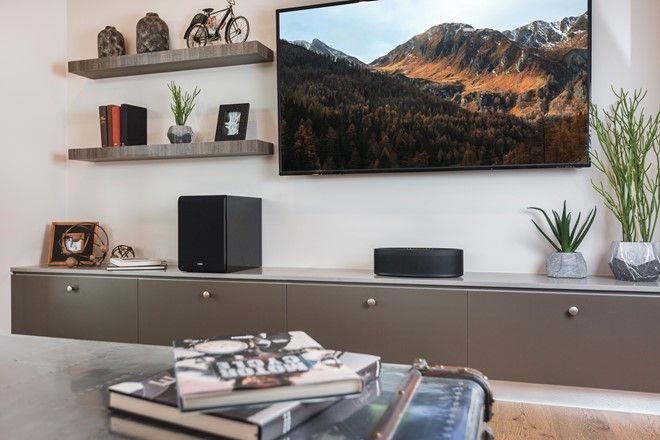 A living room with a flat screen tv on the wall.