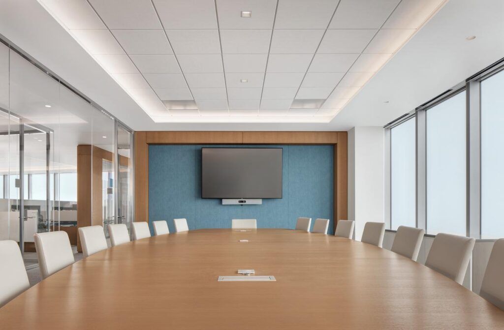 An empty conference room with a long wooden table and chairs.