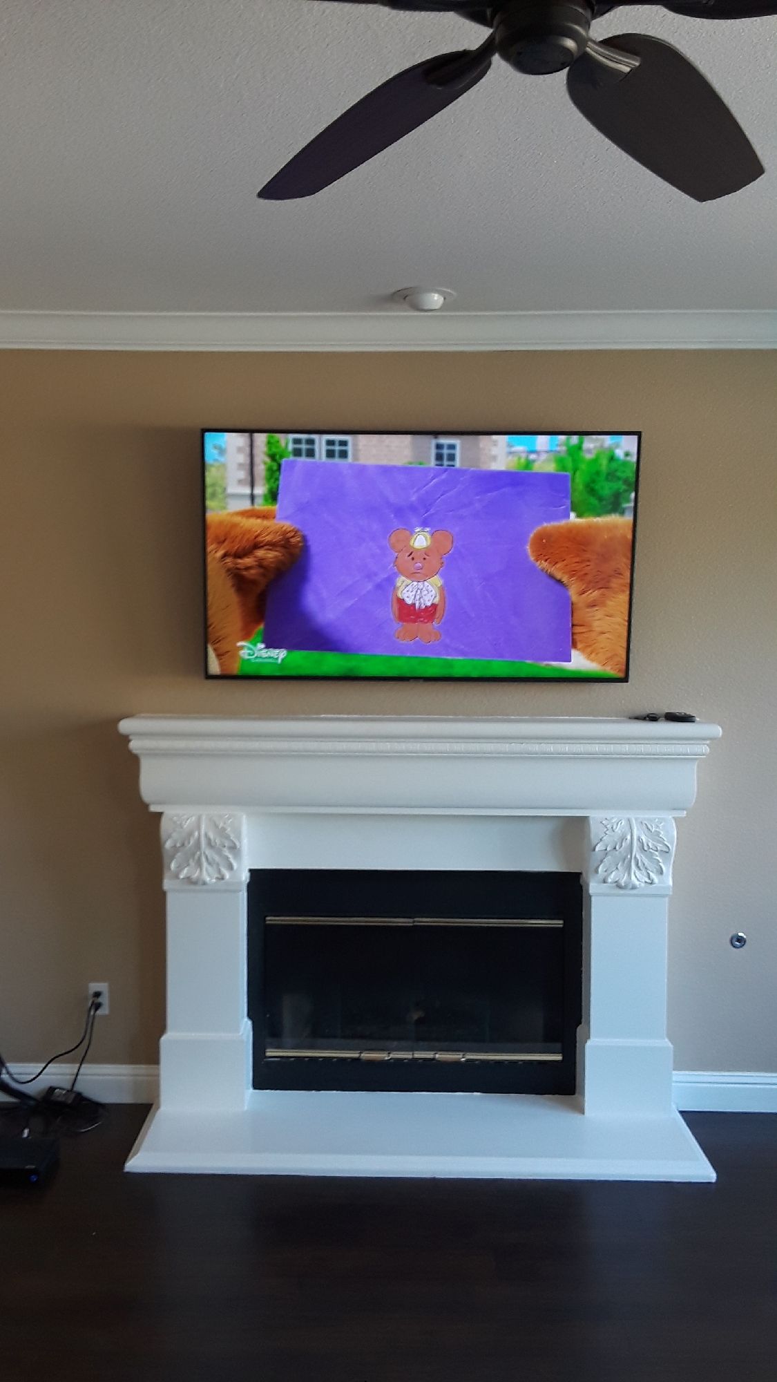 A television is mounted above a fireplace in a living room.