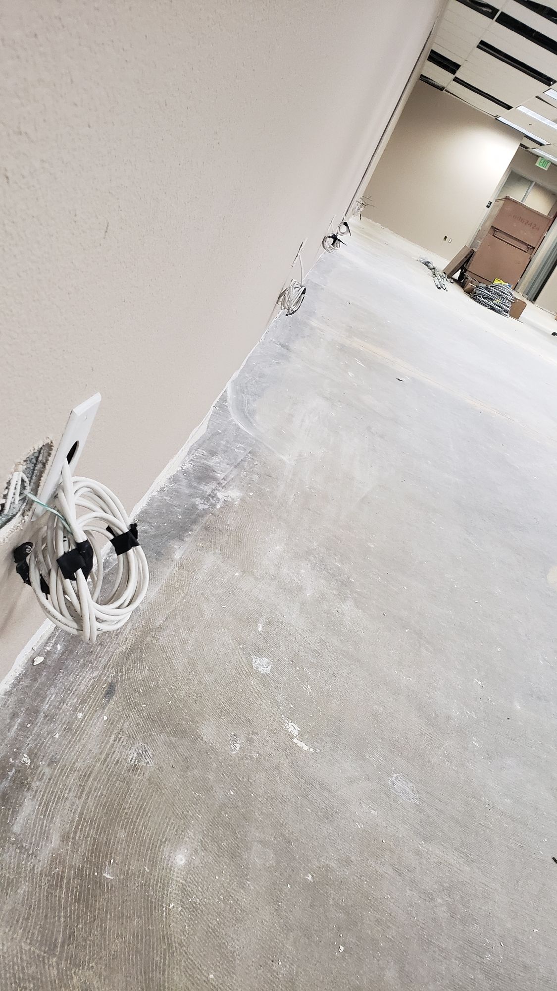 A room with a concrete floor and a white wall.