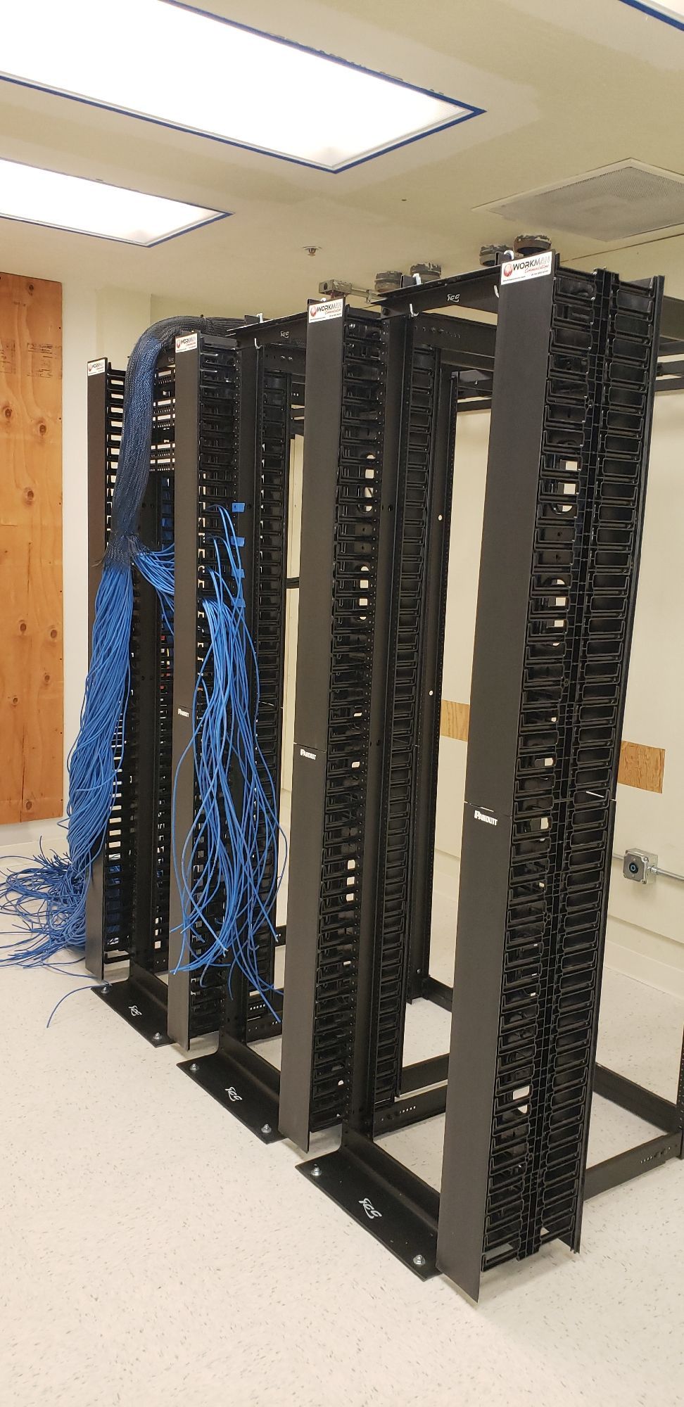 A bunch of wires are hanging from a rack in a room.