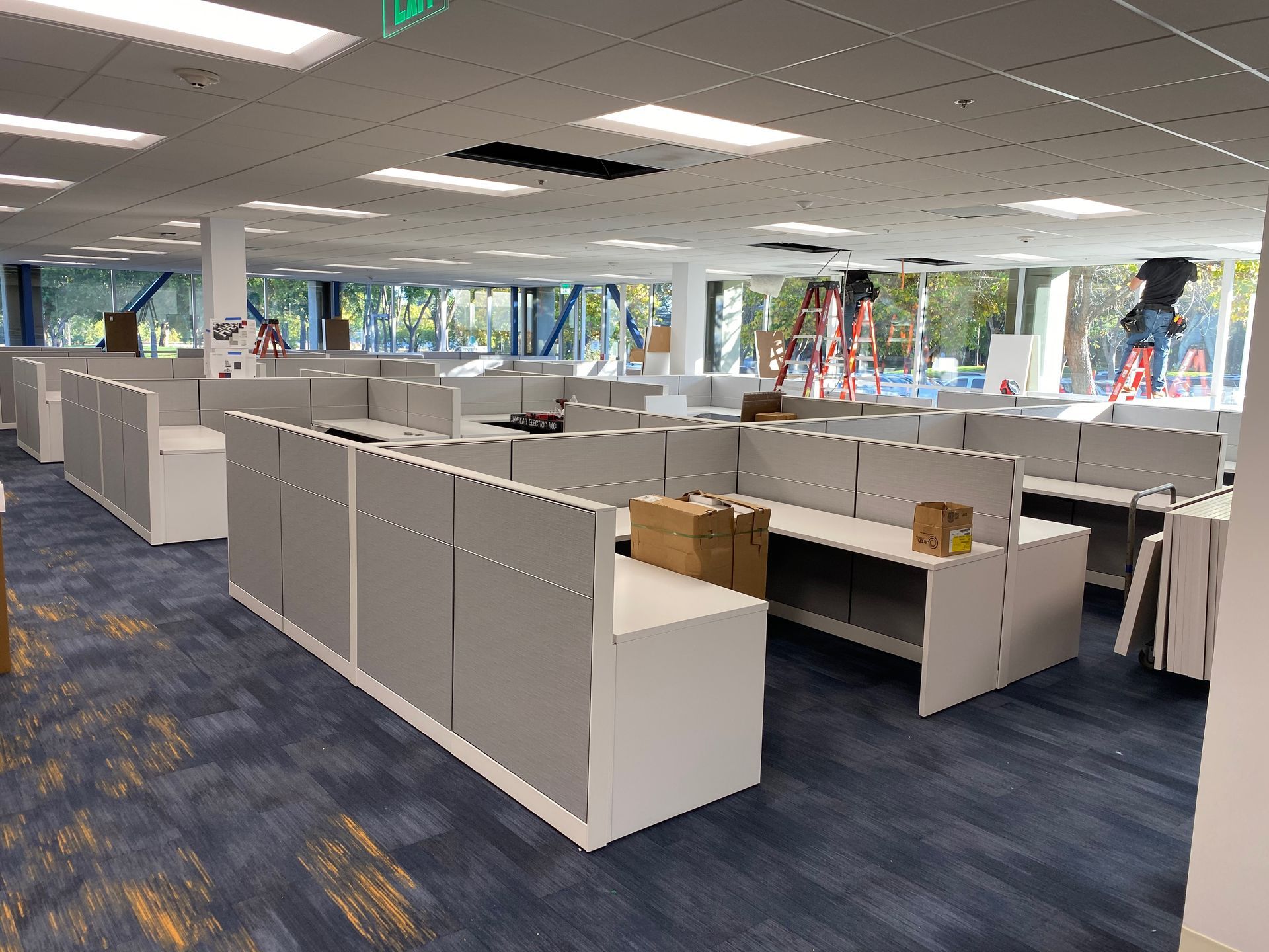 A large office with a lot of cubicles and desks.