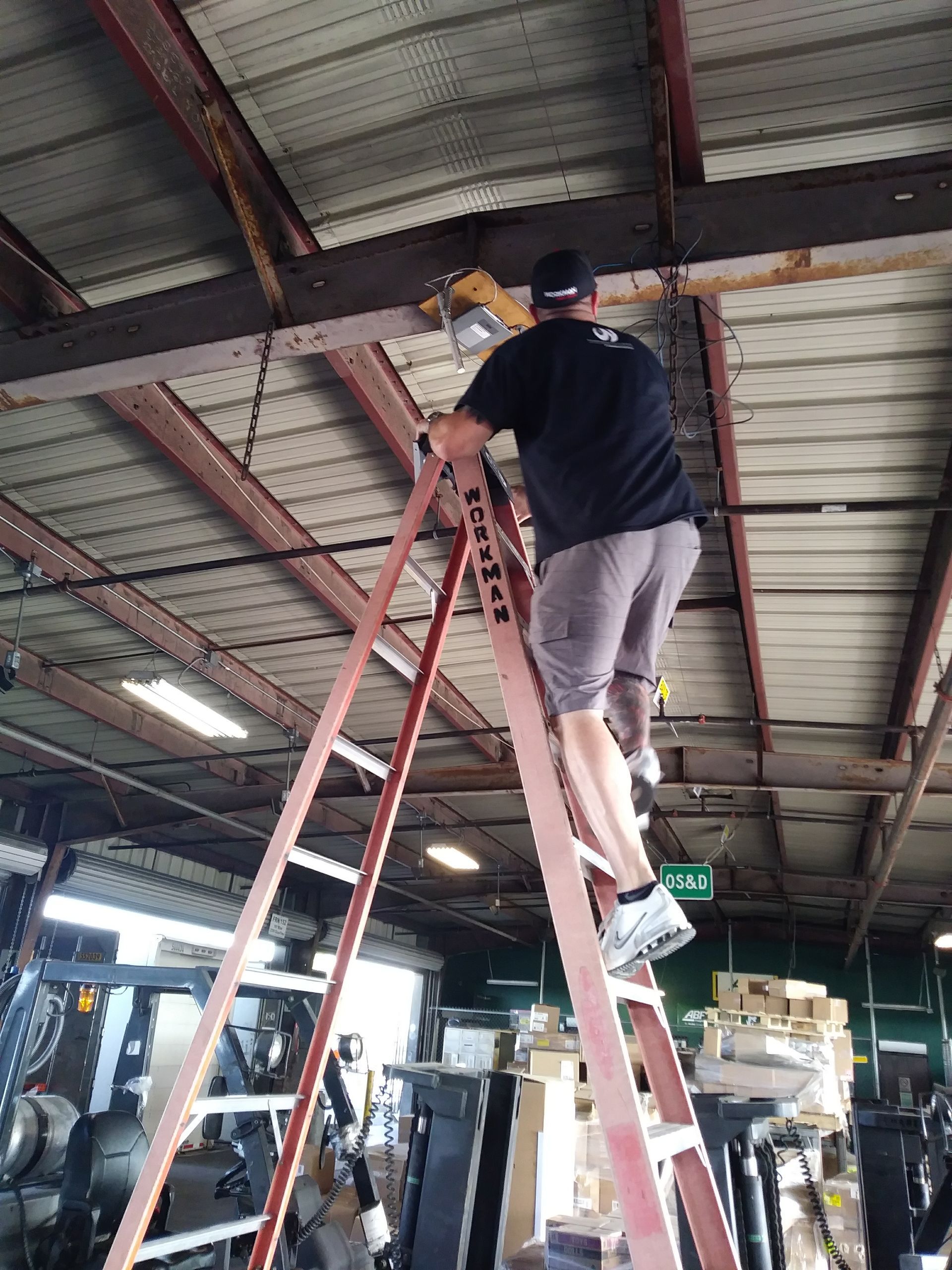 A man is standing on a ladder in a garage