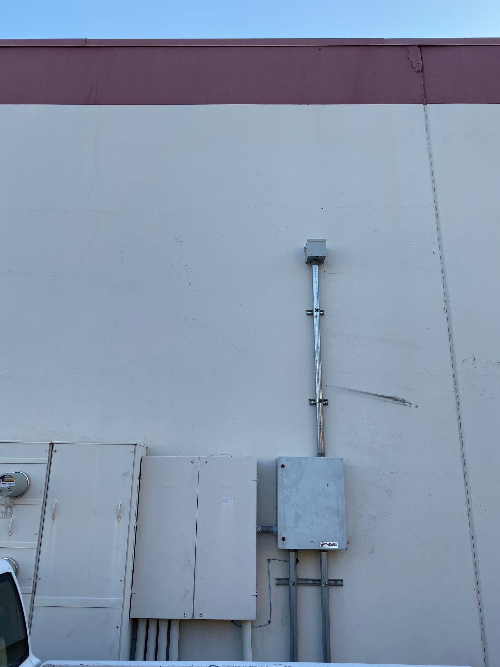 A white truck is parked on the side of a building