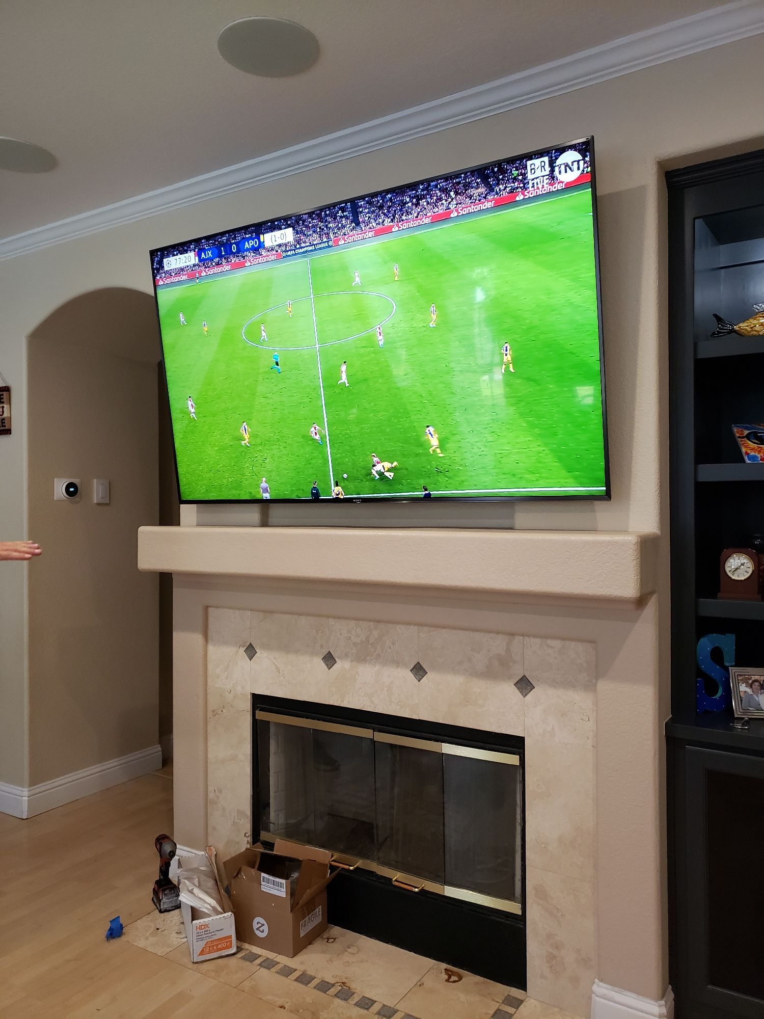 A flat screen tv is mounted above a fireplace in a living room.