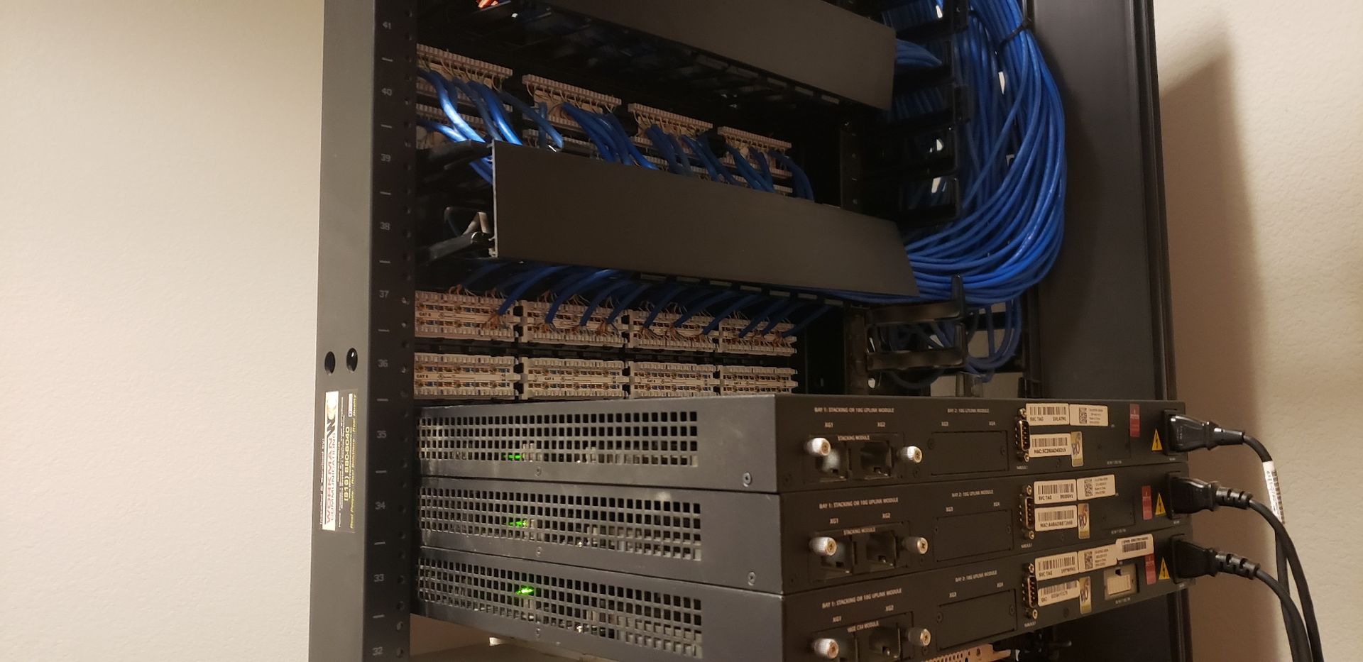 A server rack with a lot of wires coming out of it.