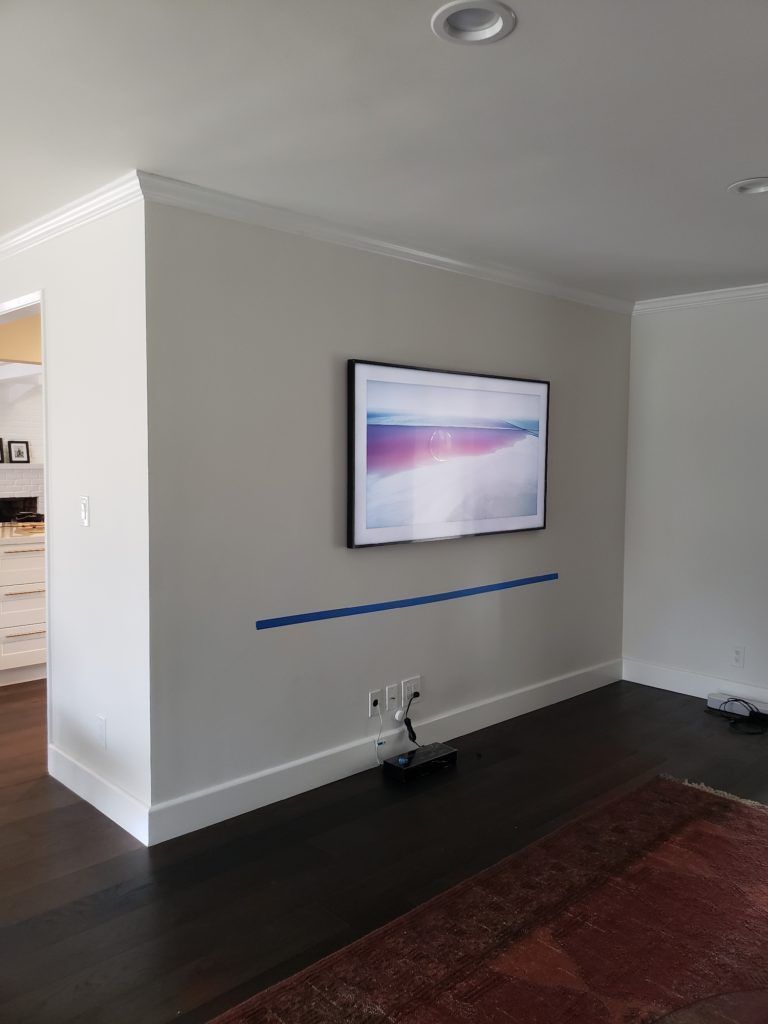 A living room with a flat screen tv mounted on the wall.