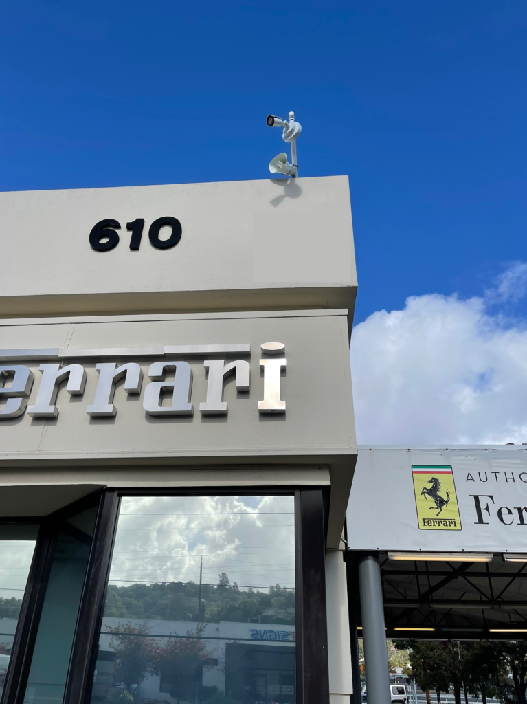 A ferrari dealership has a camera on top of the building