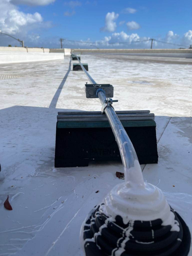 A close up of a pipe on a roof with a blue sky in the background