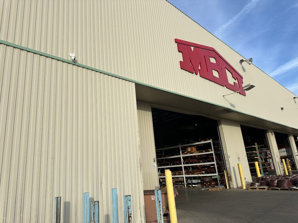 A large warehouse with a large red sign on the side of it.