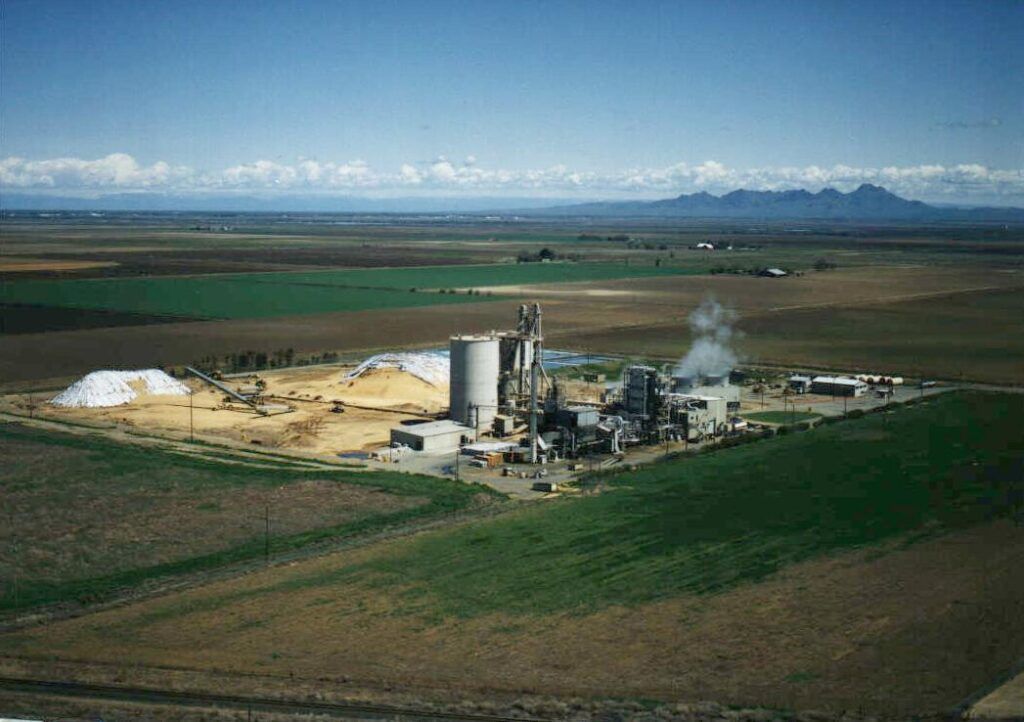 An aerial view of a factory in the middle of a field.