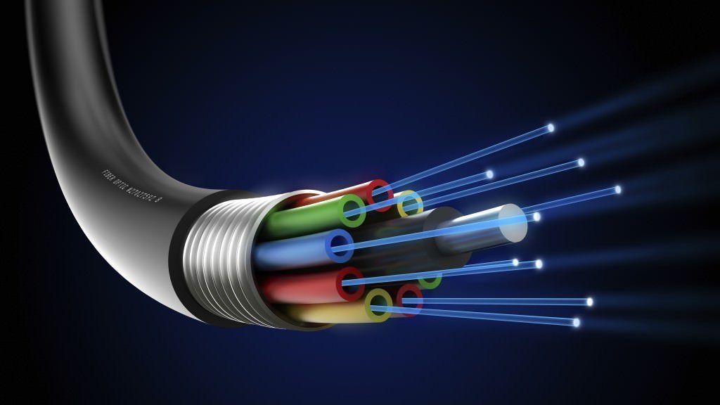 A close up of an optical fiber cable with light coming out of it.