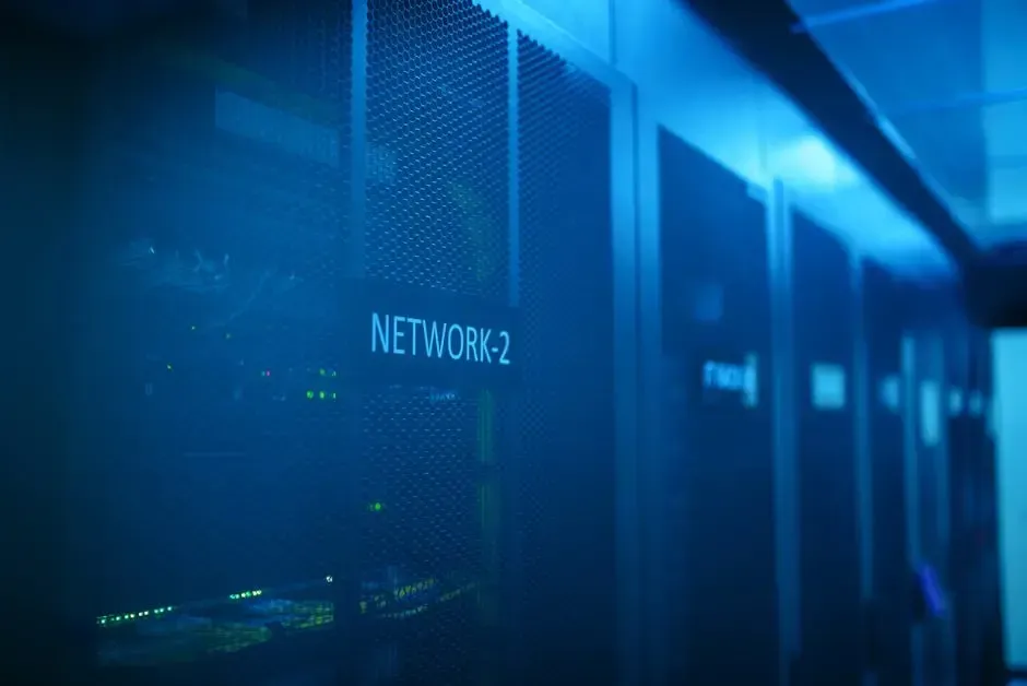 A row of servers in a data center with the word network on the wall.