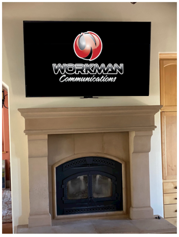 A fireplace with a tv above it that says workman communications