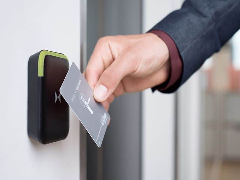 A person is using a smart card to open a door.