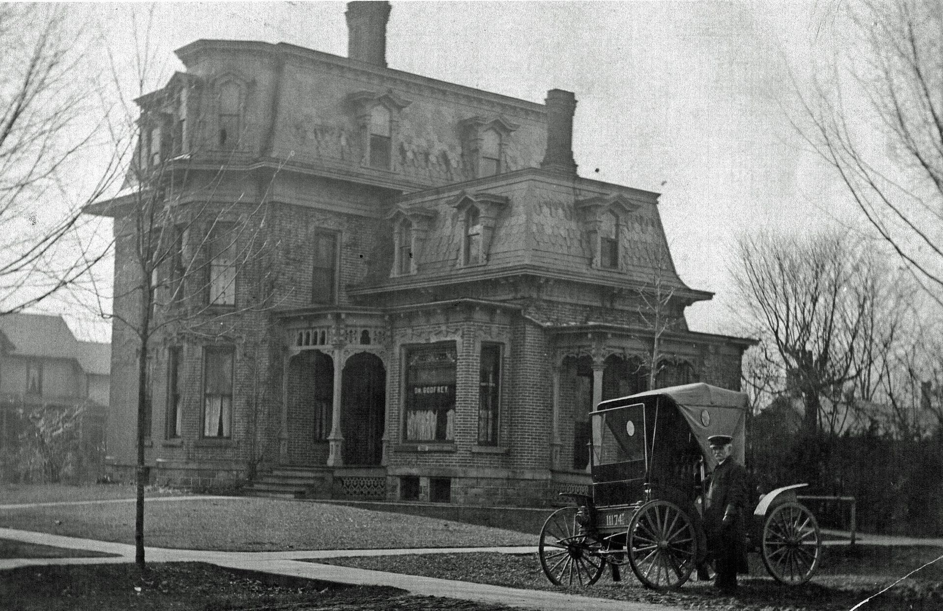 The front door of a house with a porch and plants in front of it.
