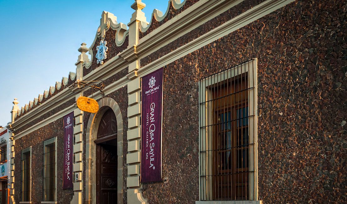 Un edificio grande con un cartel morado en el costado.