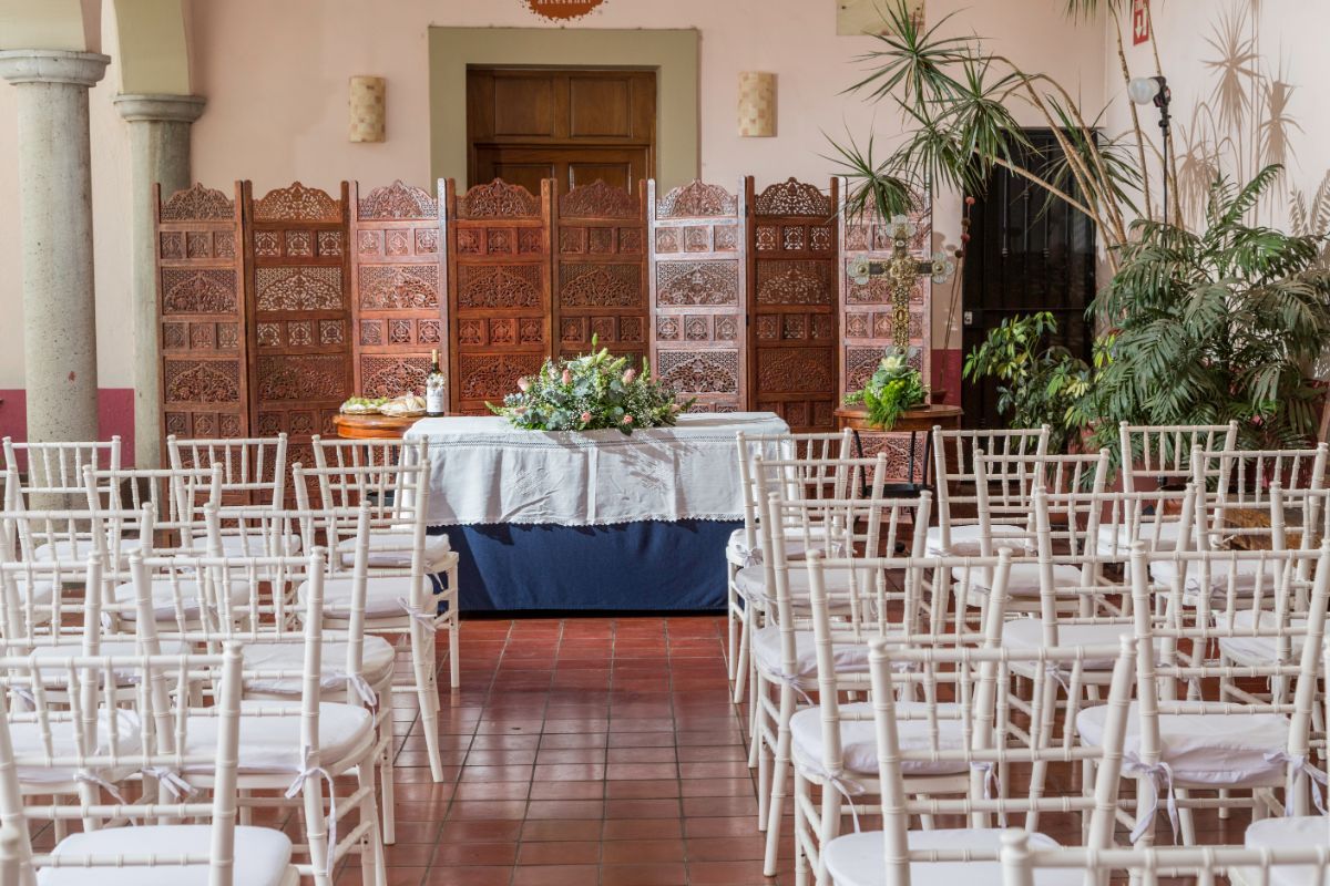 Una habitación llena de sillas y una mesa con flores.