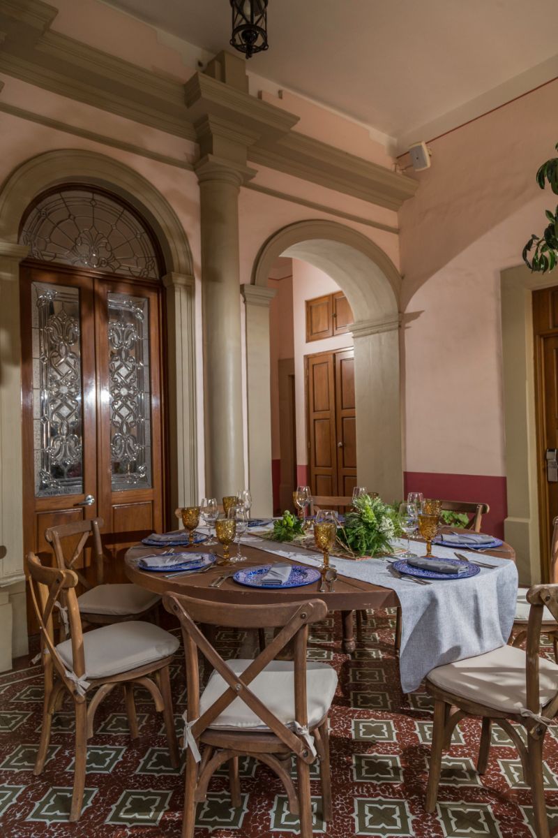 Un comedor con mesas y sillas preparadas para comer.