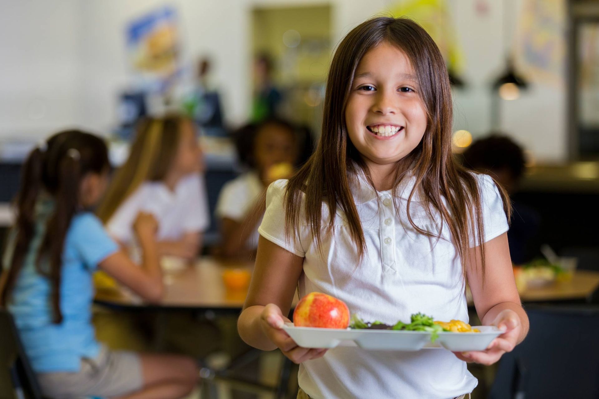 Happy Elementary School Girl With Healthy Food In Cafeteria — Corcoran, MN — St John's Evangelical Lutheran