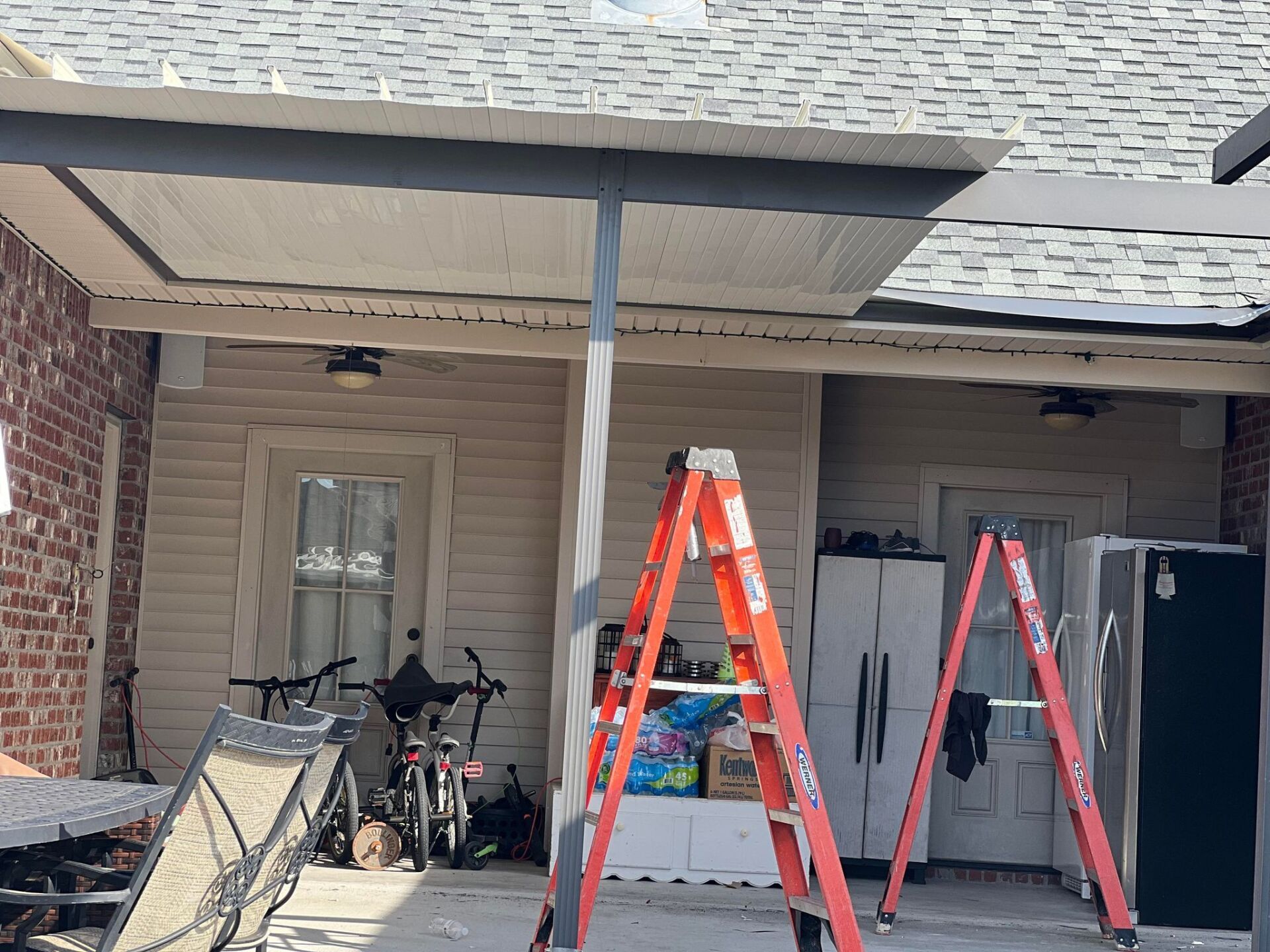 Two ladders are sitting in front of a house.